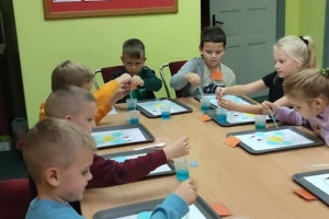 Uczestnicy zajęć wykonują prace plastyczne