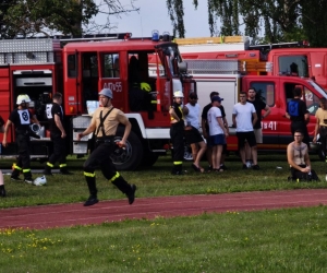 Zdjęcie przedstawia strażaków podczas brania udziału w konkurencjach pożarniczych.