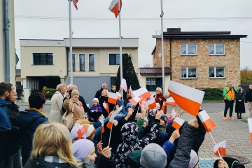 Powiewające bialo-czerwone flagi trzymane przez dzieci